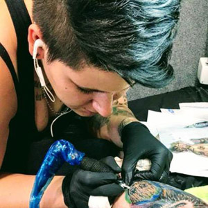 Tätowiererin Steffi konzentriert sich auf ein Tattoo, demonstriert ihre Fähigkeiten in Realistic und feinen Linien.